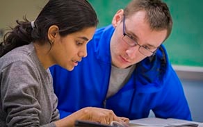 Economics teaching assistant tutoring a student in Fronczak Hall. 
