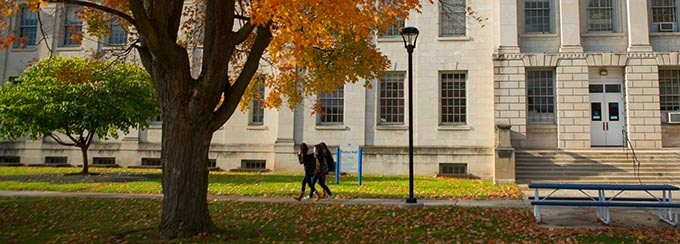 Students walking in form of Parker Hall on UB's South Campus in the fall. 
